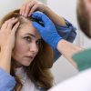 Mujer está siendo examinada en el cabello por un médico