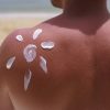 Espalda de hombre con un sol dibujado con fotoprotector