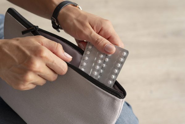 Una persona guarda unos blister de comprimidos en un neceser para un viaje